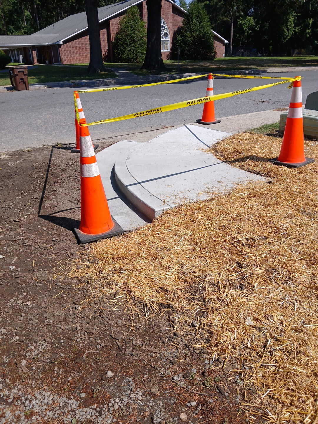 After: the same walkway removed and repoured over a corrected base, with the disturbed ground strawed and restored
