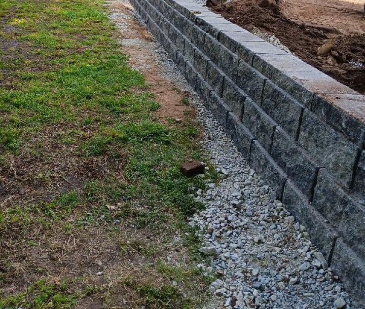 Block retaining wall with drainage stone at the base